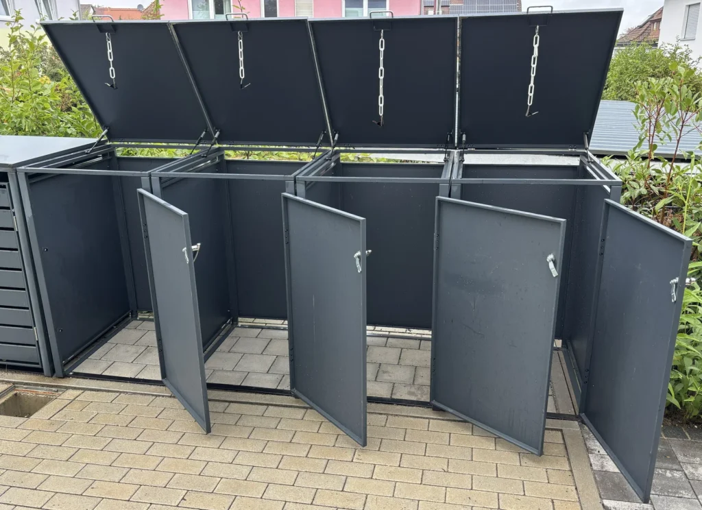 Geöffnete Türen der Metzler Mülltonnenbox für die Entnahme einer Mülltonne