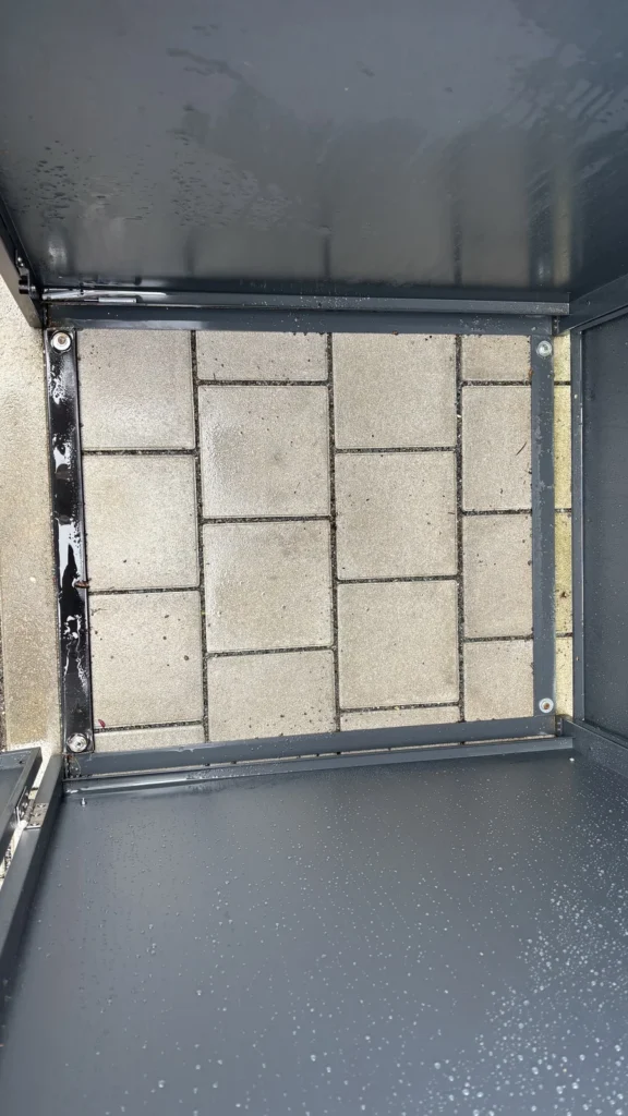 Verankerung der Metzler Mülltonnenbox auf dem Pflaster mit darunterliegendem Fundament