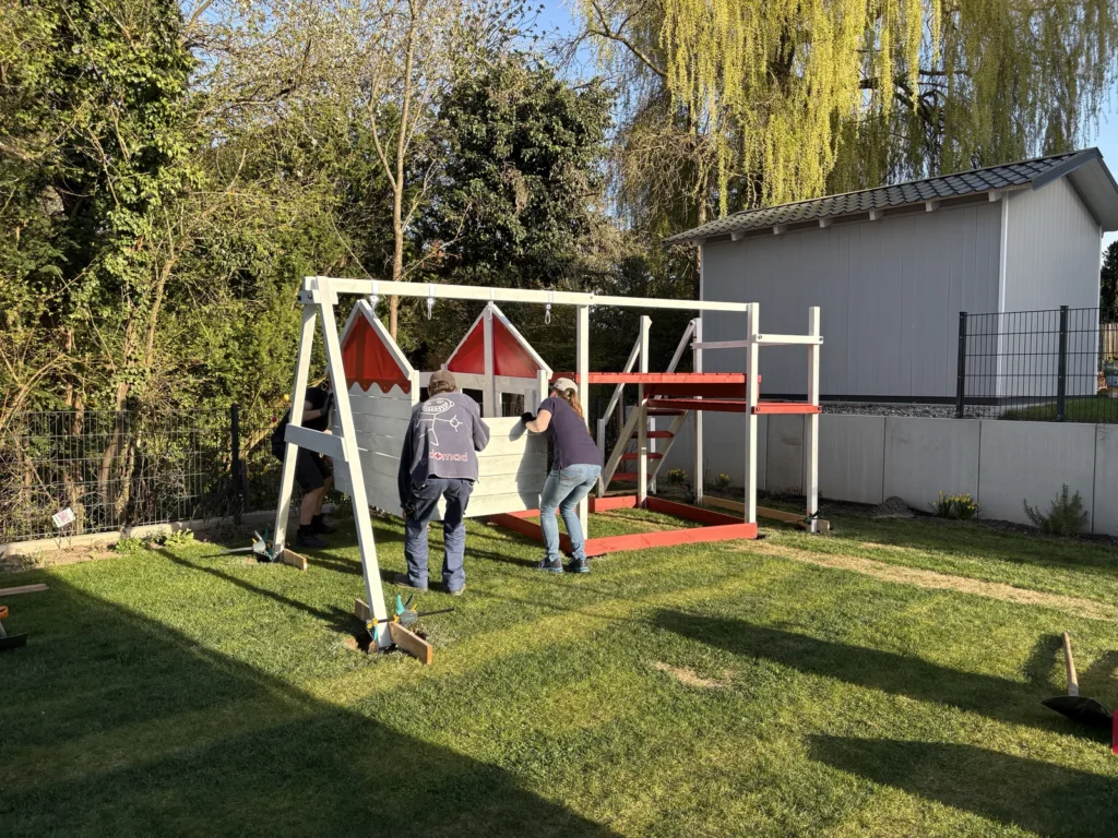 Vier Personen tragen das Spielhaus des Wickey Smart Seaway zum Grundturm