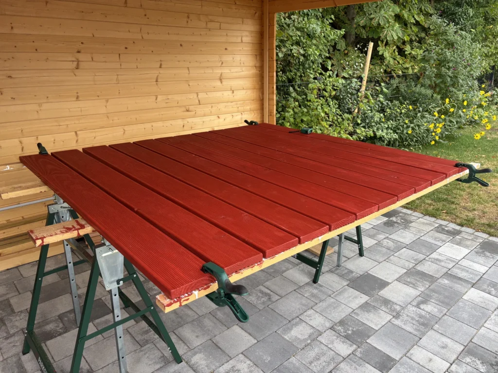 Ausgerichtete Bretter für den Wickey Sandkasten Klappdeckel auf Arbeitsböcken mit Klemmzwingen