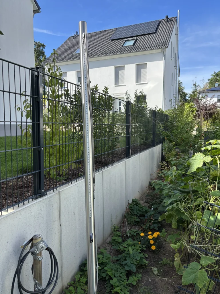 Höhenverstellbarer Edelstahlmast mit Flaschenzug für das Sonnensegel an den L-Steinen
