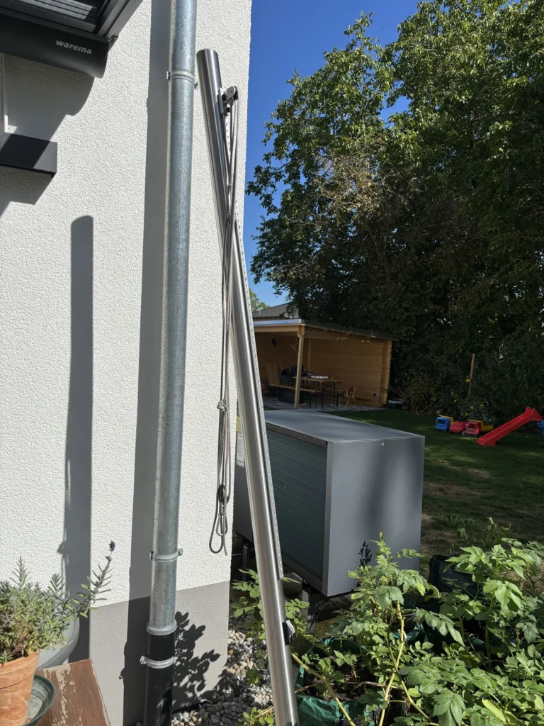 Höhenverstellbarer Edelstahlmast mit Flaschenzug an der Hausseite