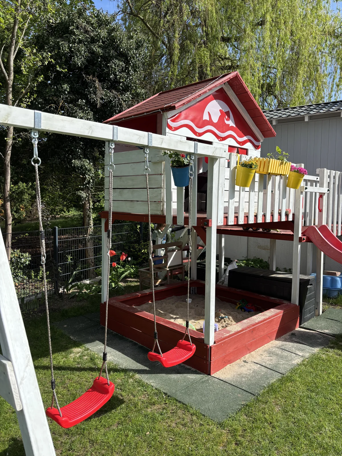 Fertig aufgebauter Spielturm mit Schaukel und Fallschutzmatten