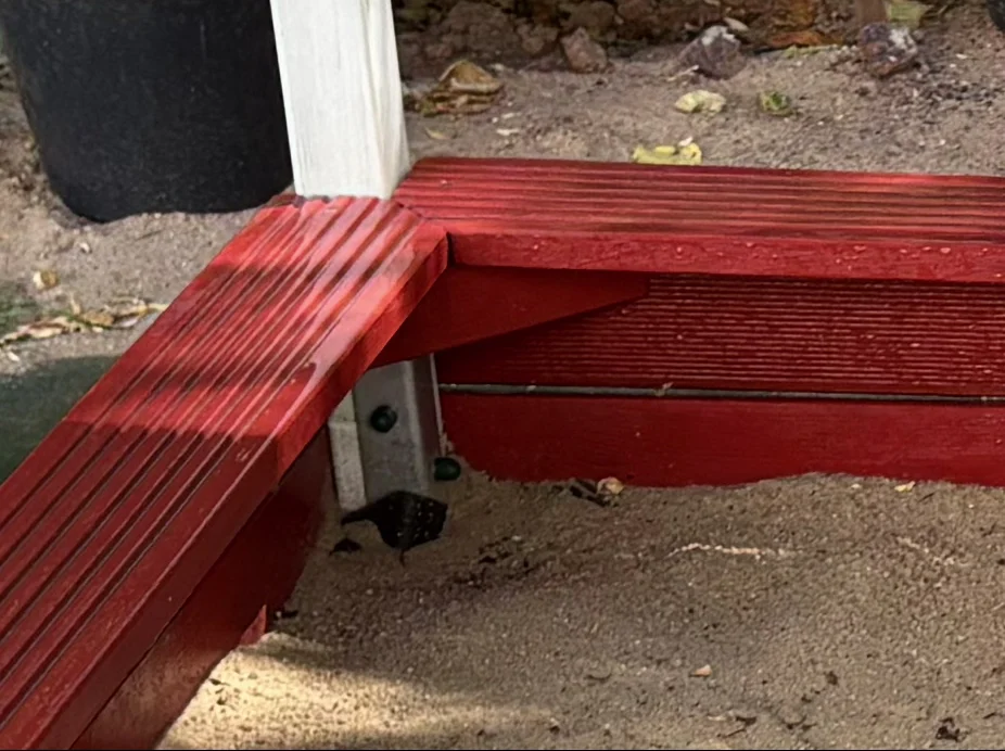 Eckkonstruktion des selbst gebauten Sandkastens mit Sitzfläche