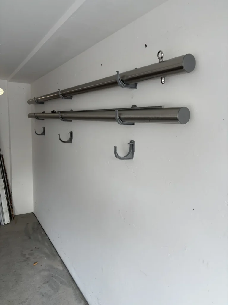 Zwei Sonnensegelmasten in der Wandhalterung der Garage