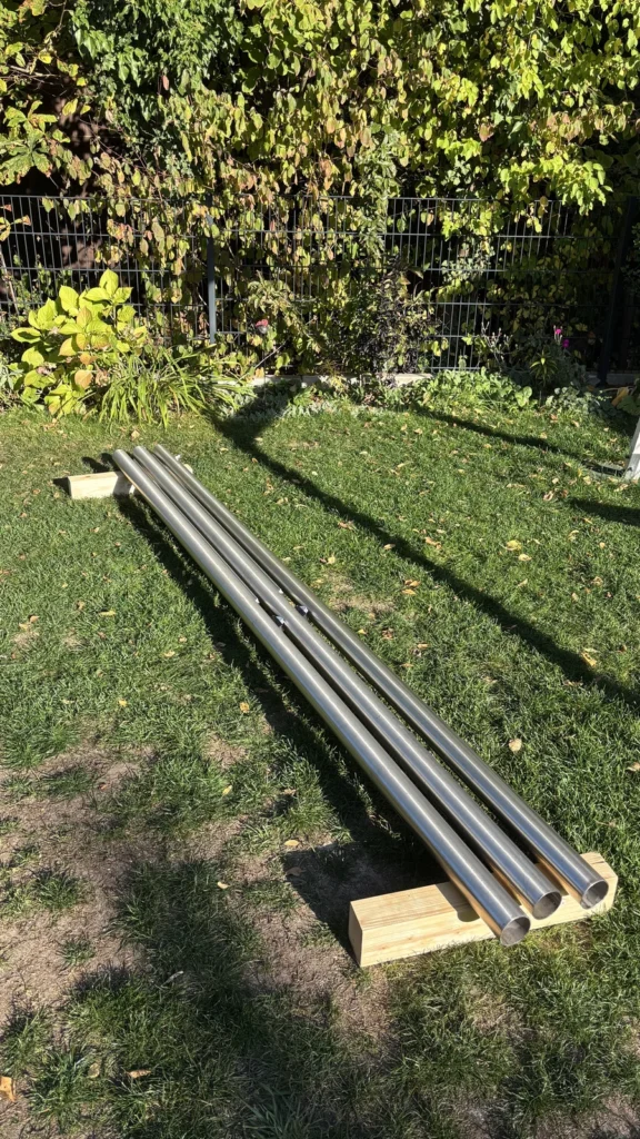 Drei 3 m lange Edelstahlmasten des Sonnensegels auf Holzbalken